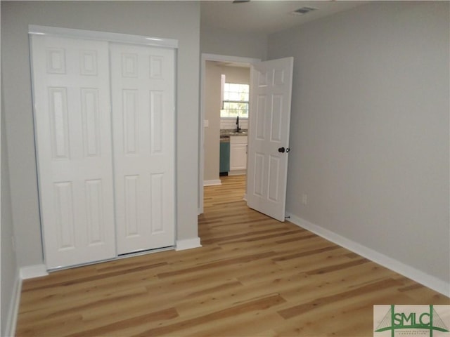 unfurnished bedroom with a closet and light hardwood / wood-style flooring