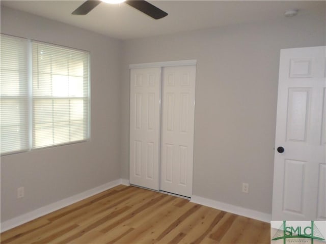 unfurnished bedroom with ceiling fan, light wood-type flooring, and a closet