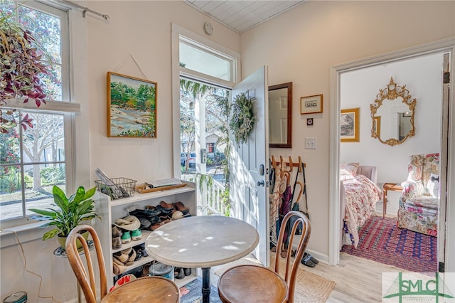 dining room featuring light hardwood / wood-style flooring, a healthy amount of sunlight, and wood ceiling