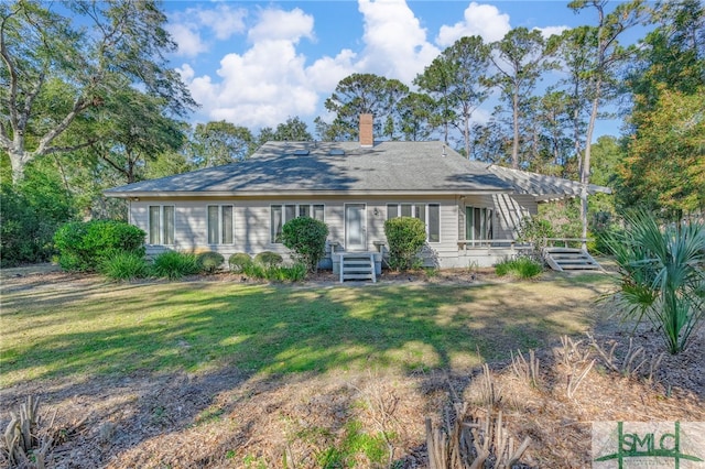 rear view of property featuring a lawn