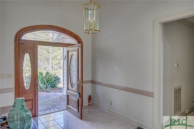 foyer featuring ornamental molding and a chandelier