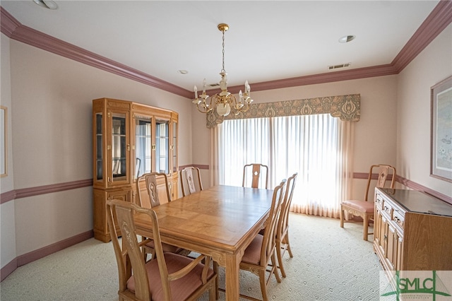 carpeted dining room featuring ornamental molding and an inviting chandelier