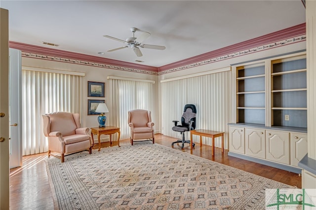 sitting room featuring ceiling fan, light hardwood / wood-style floors, and ornamental molding