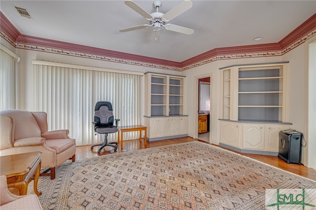 living area with ceiling fan, light hardwood / wood-style flooring, and ornamental molding