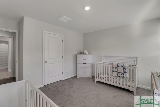 bedroom featuring light colored carpet and a nursery area