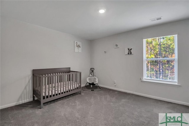 unfurnished bedroom with carpet flooring and a nursery area