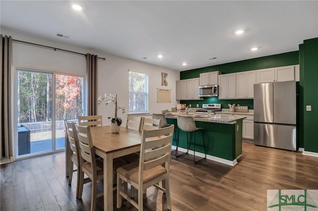 dining space with dark hardwood / wood-style floors, sink, and a wealth of natural light