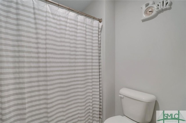 bathroom featuring a shower with shower curtain and toilet