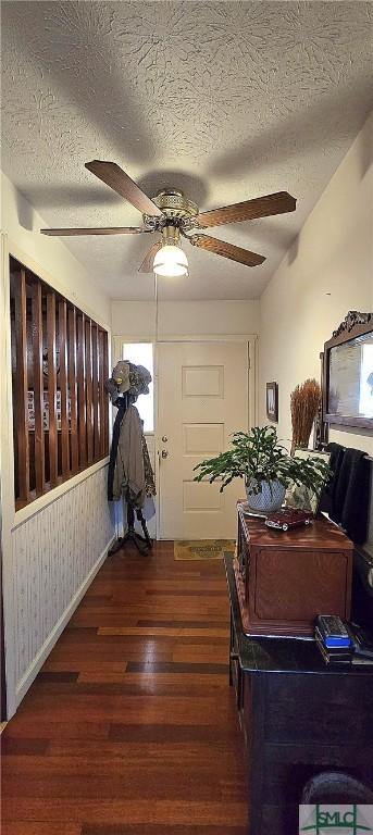 corridor featuring dark wood-type flooring and a textured ceiling