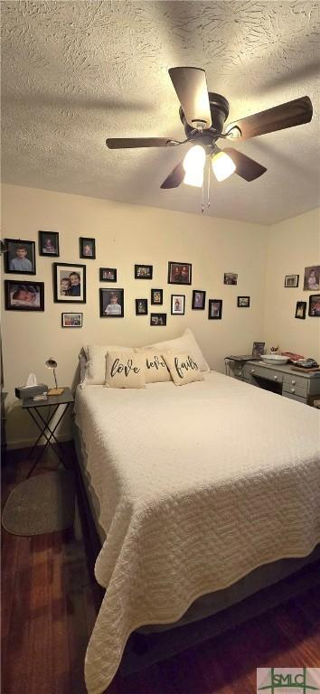 bedroom featuring ceiling fan, wood-type flooring, and a textured ceiling