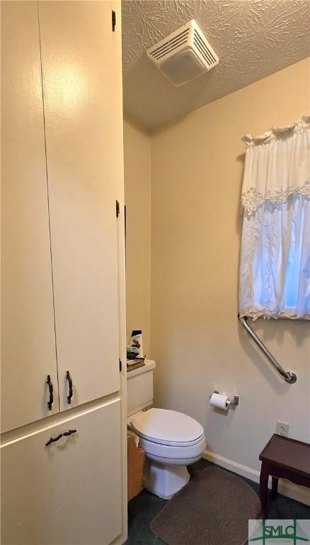 bathroom featuring a textured ceiling and toilet