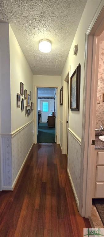 hall featuring dark hardwood / wood-style floors and a textured ceiling