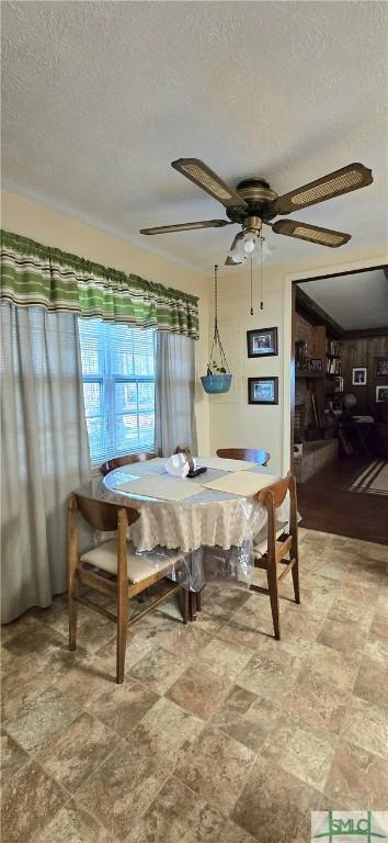 dining space featuring ceiling fan and a textured ceiling