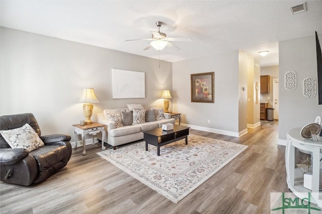 living room featuring ceiling fan and light hardwood / wood-style flooring