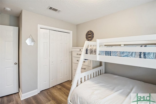 bedroom featuring a closet, a textured ceiling, and hardwood / wood-style flooring