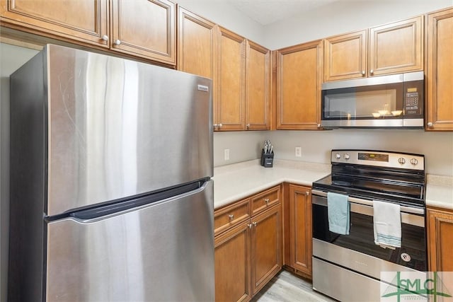 kitchen with appliances with stainless steel finishes and light wood-type flooring