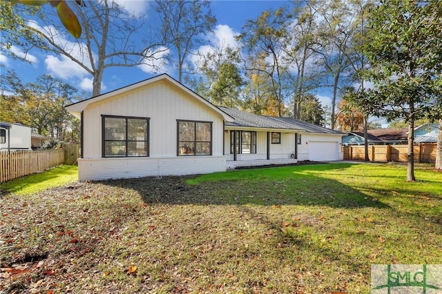 back of house with a yard and a garage