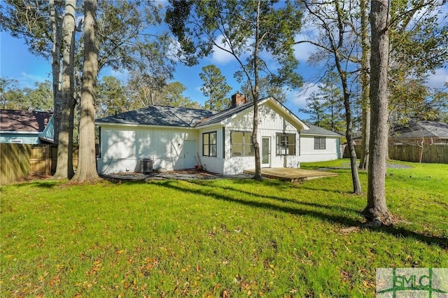 rear view of house with a yard and a wooden deck