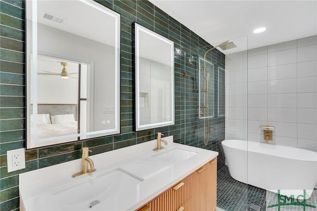 bathroom with ceiling fan, vanity, and tile walls