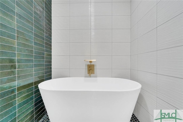 bathroom featuring a bath and tile walls