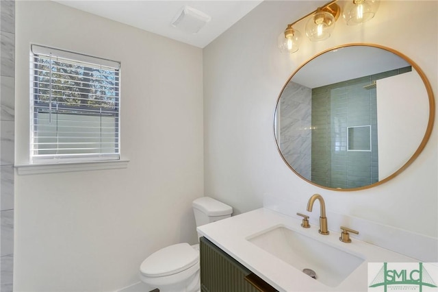 bathroom with vanity, toilet, and a shower