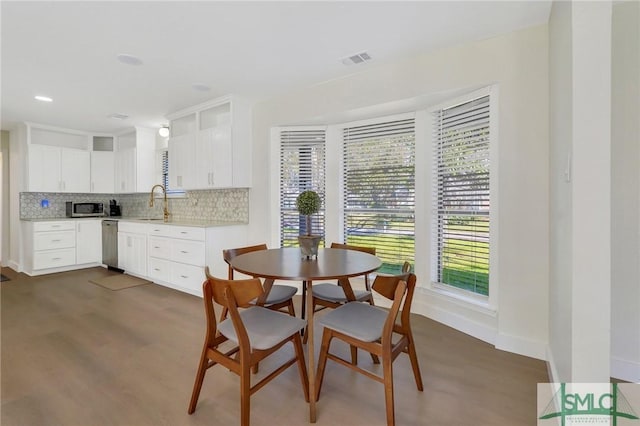 dining area with sink and dark wood-type flooring