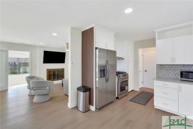 kitchen with white cabinets, stainless steel appliances, and light hardwood / wood-style floors