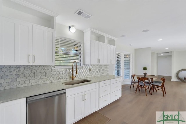 kitchen with white cabinetry, sink, tasteful backsplash, stainless steel dishwasher, and hardwood / wood-style flooring