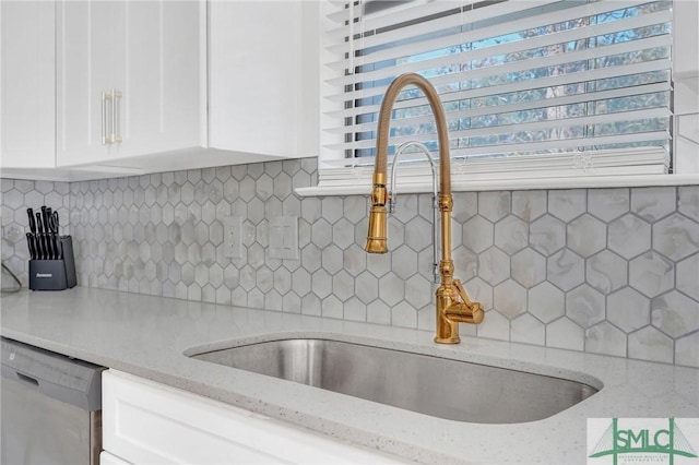 kitchen featuring white cabinetry, light stone countertops, sink, and stainless steel dishwasher