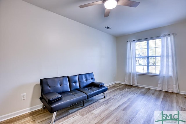 living area featuring light wood-type flooring and ceiling fan