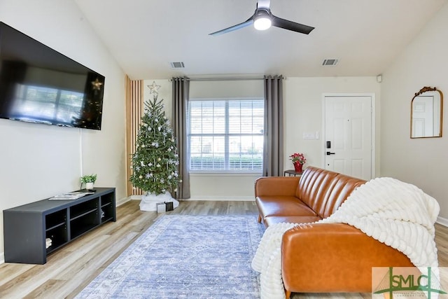 living room with lofted ceiling, ceiling fan, and light hardwood / wood-style flooring