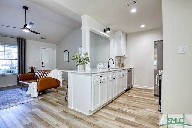 kitchen featuring white cabinets, ceiling fan, light wood-type flooring, kitchen peninsula, and appliances with stainless steel finishes