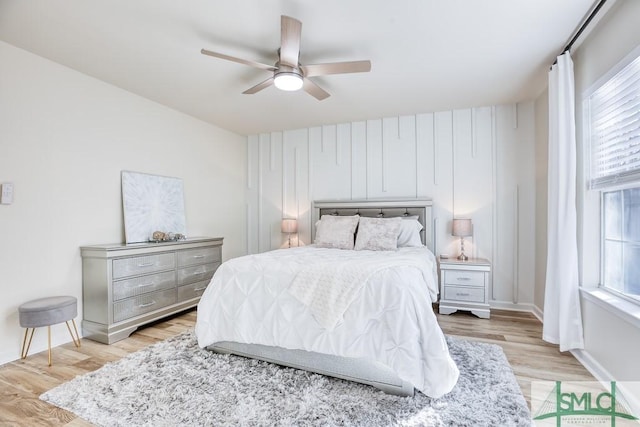 bedroom with multiple windows, ceiling fan, and light wood-type flooring