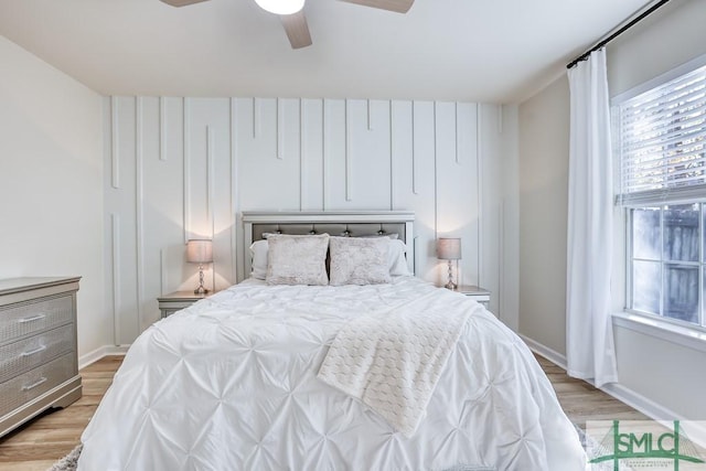 bedroom featuring ceiling fan, light hardwood / wood-style flooring, and multiple windows