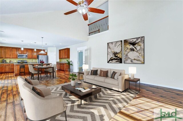 living room featuring ceiling fan, dark hardwood / wood-style flooring, and a high ceiling