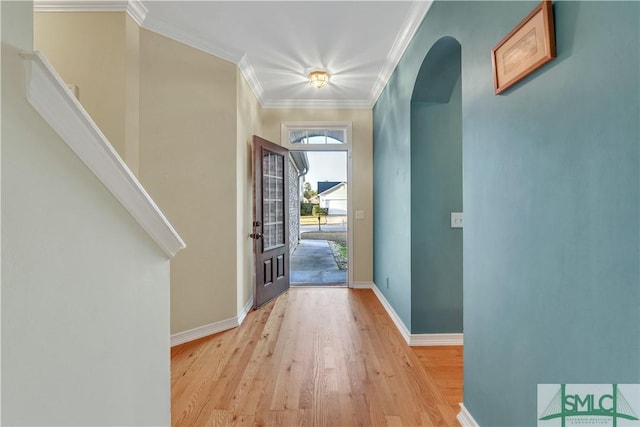 entryway featuring light wood-type flooring and crown molding