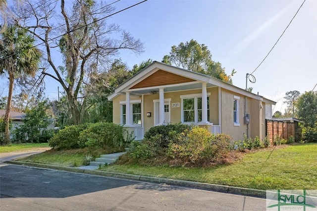 view of front of house with covered porch and a front lawn