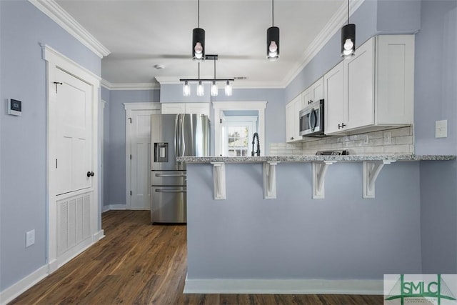 kitchen with a breakfast bar, dark wood-type flooring, white cabinets, kitchen peninsula, and stainless steel appliances