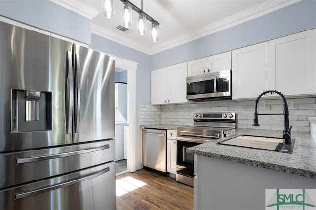 kitchen featuring white cabinets, crown molding, dark hardwood / wood-style floors, decorative light fixtures, and stainless steel appliances