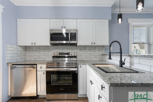 kitchen with light stone countertops, white cabinetry, sink, appliances with stainless steel finishes, and ornamental molding