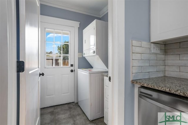 laundry area featuring crown molding, light tile patterned floors, and stacked washer and clothes dryer