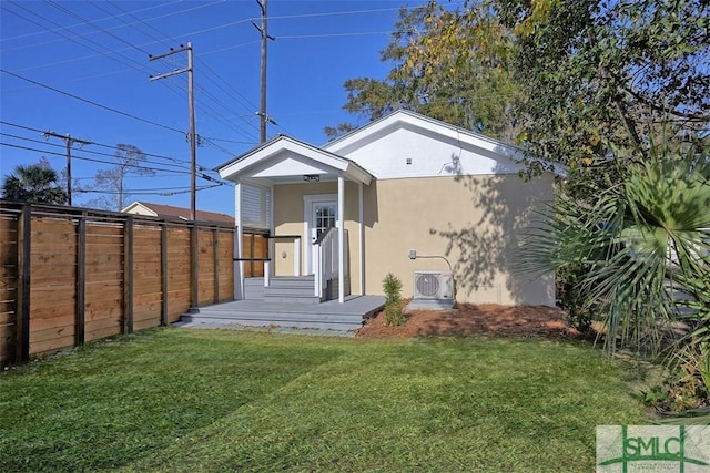 rear view of property with a lawn and ac unit