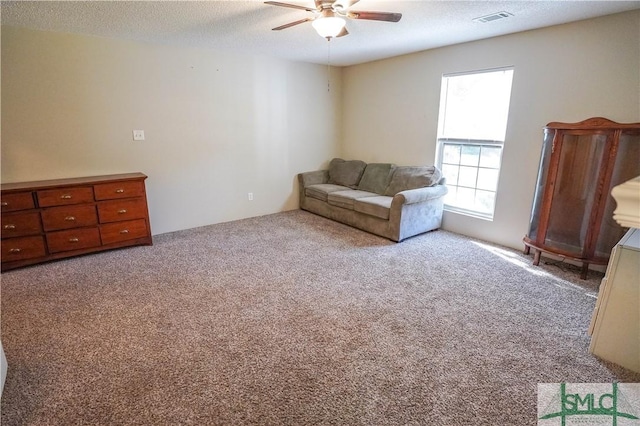 unfurnished room featuring ceiling fan, light colored carpet, and a textured ceiling