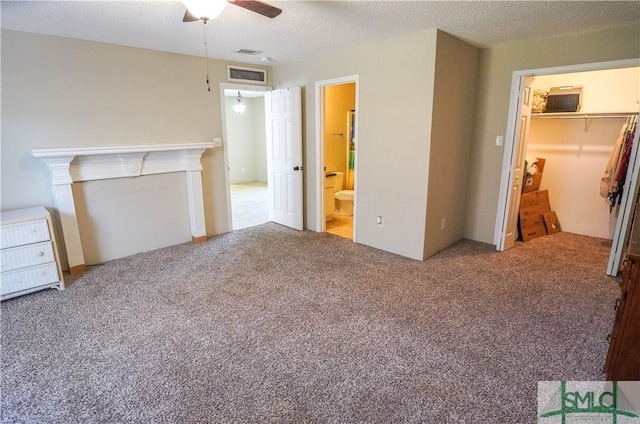 unfurnished bedroom featuring carpet, connected bathroom, a closet, and ceiling fan