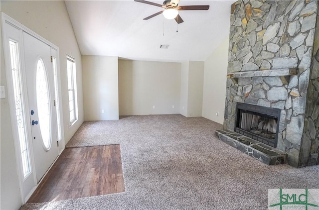 unfurnished living room with carpet flooring, vaulted ceiling, a fireplace, and ceiling fan