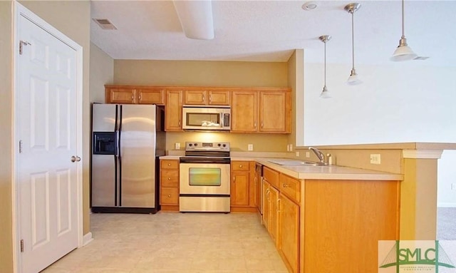 kitchen with hanging light fixtures, stainless steel appliances, and sink