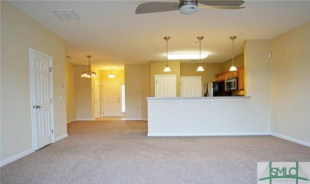 unfurnished living room with ceiling fan and light carpet