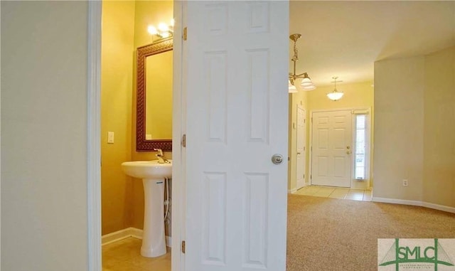 hall featuring light colored carpet and sink