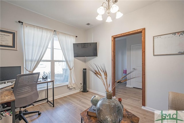 home office featuring a notable chandelier and light hardwood / wood-style flooring