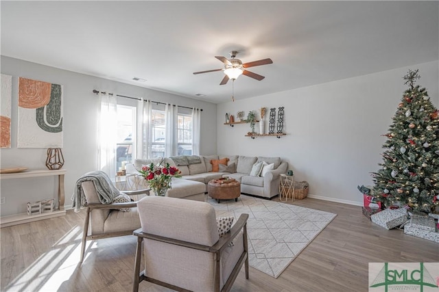 living room featuring ceiling fan and light hardwood / wood-style floors